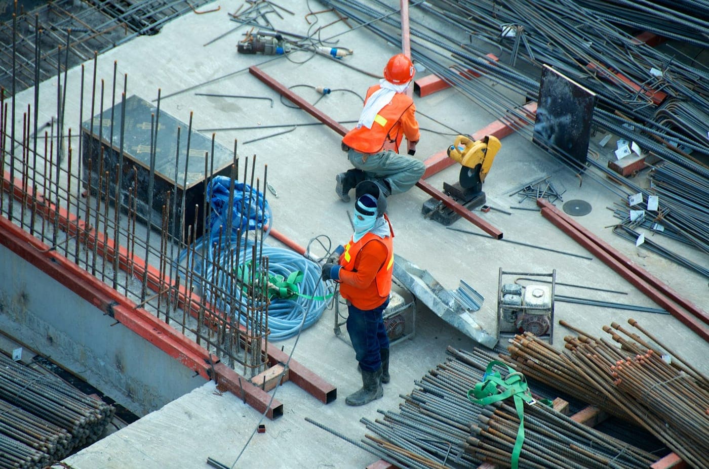Construction crew in hard hats working among steel reinforcement on site