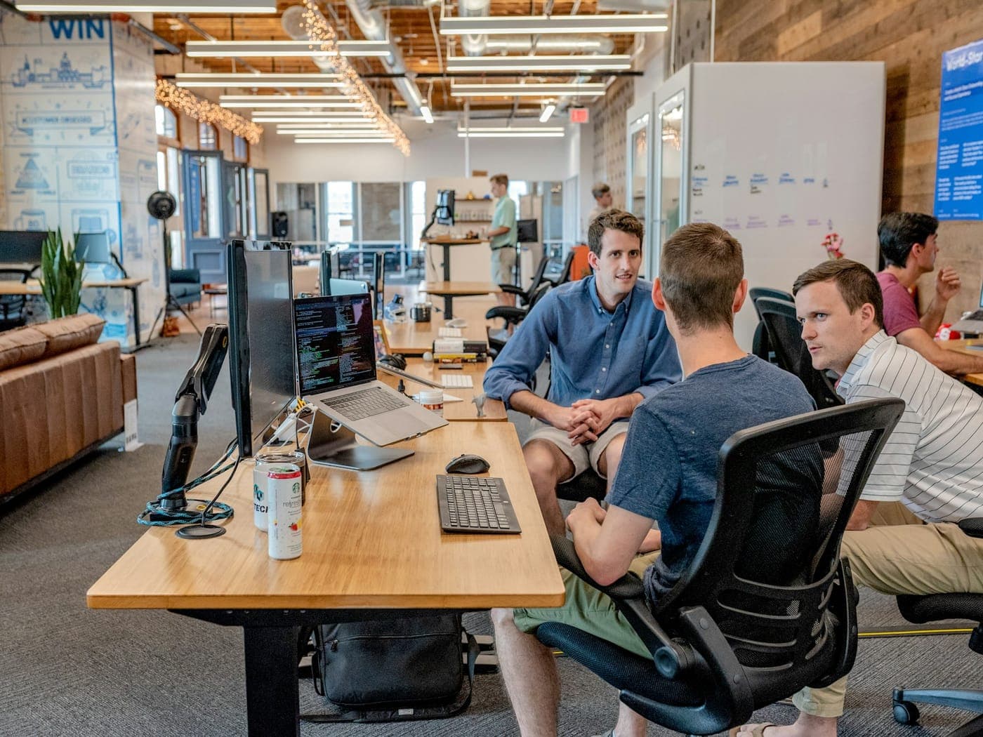 Sales team collaborating around desks in a bright open office